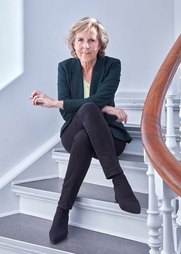 Conni Hedegaard sidder på en trappe.